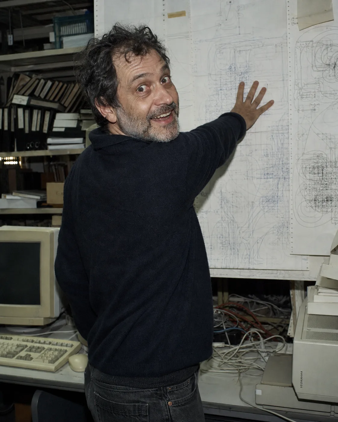 Candid portrait of Silas Vale beside a wall of diagrams